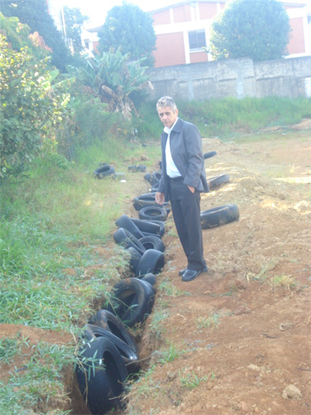 Anízio observa pneus com água parada.