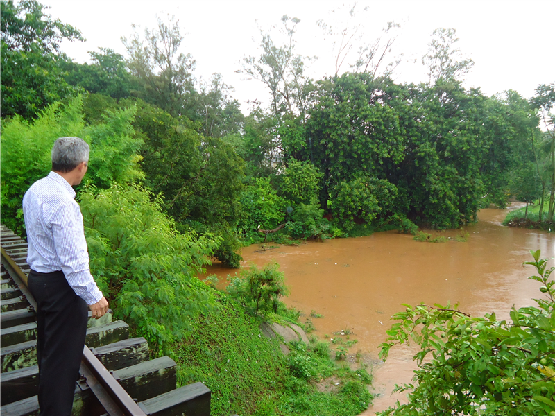 Anízio observa nível do Ribeirão dos Toledos durante chuva na tarde desta segunda-feira